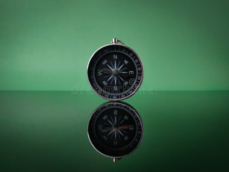 Closeup compass on green background with reflection royalty free stock photo