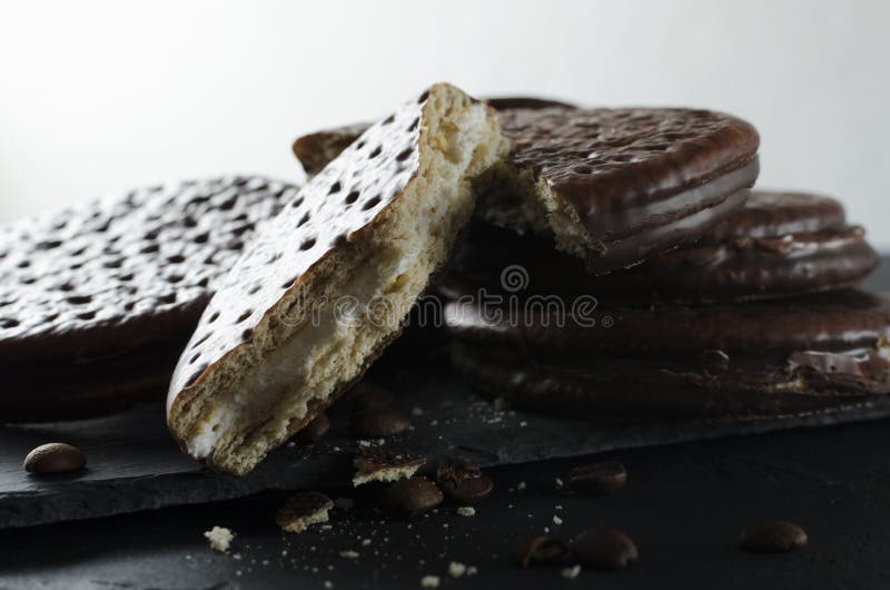 Closeup of cracked chocolate cookies, pile of chocolate biscuits with coffee taste on the black surface stock photo