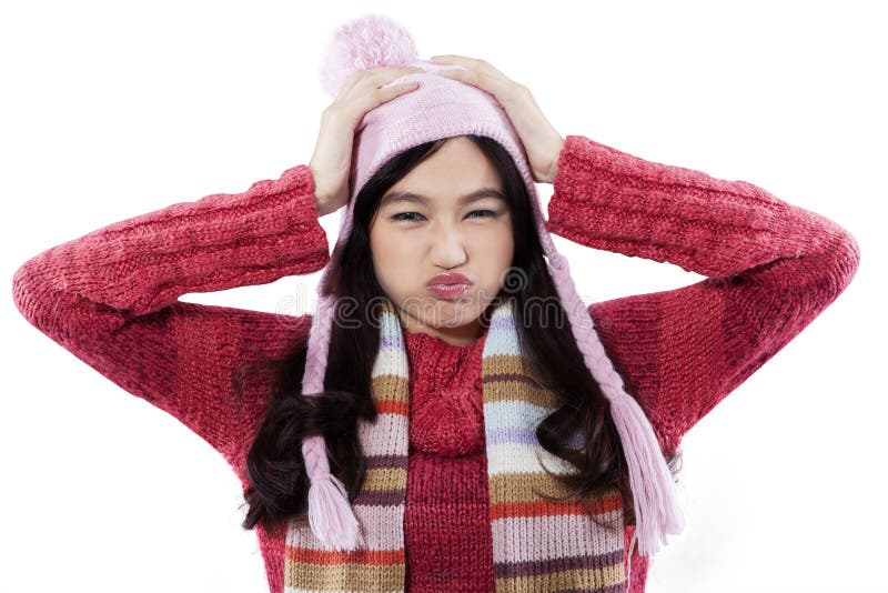 Cranky expression of young girl wearing knitted clothes and hat, isolated on white background. Cranky expression of young girl wearing knitted clothes and hat, isolated on white background