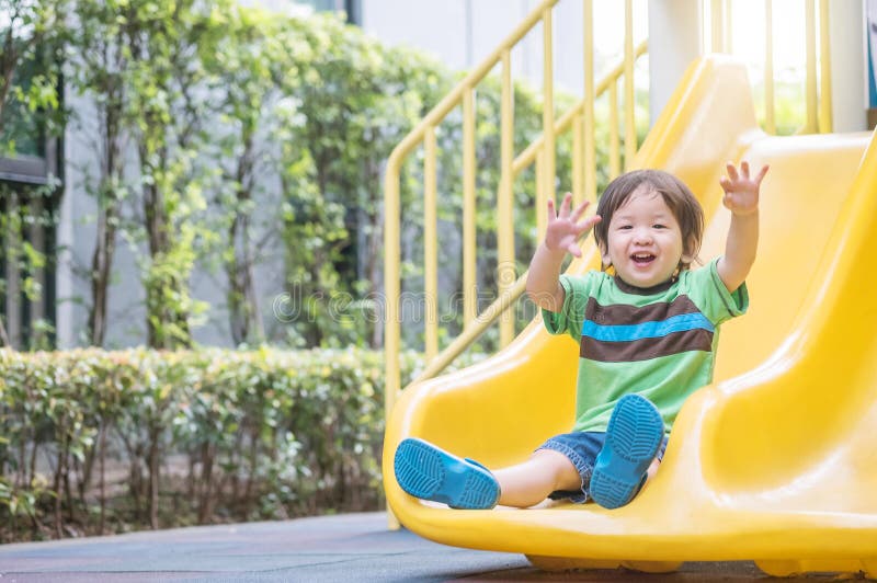 Dettagliato Carino un bambino giocare barra di scorrimento sul terreno di gioco.