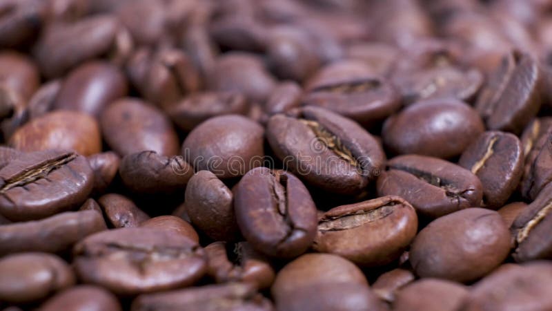 Closeup of dark roasted coffee beans on rotating table. stock video