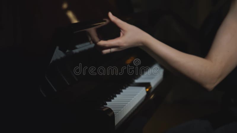 Closeup de femme commence à jouer du piano. média. femme élégante commence à jouer du jazz au piano dans le restaurant. femme élég