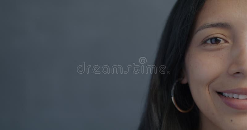 Closeup de femme hispanique joyeuse moitié visage souriant regardant la caméra sur fond noir clips vidéos