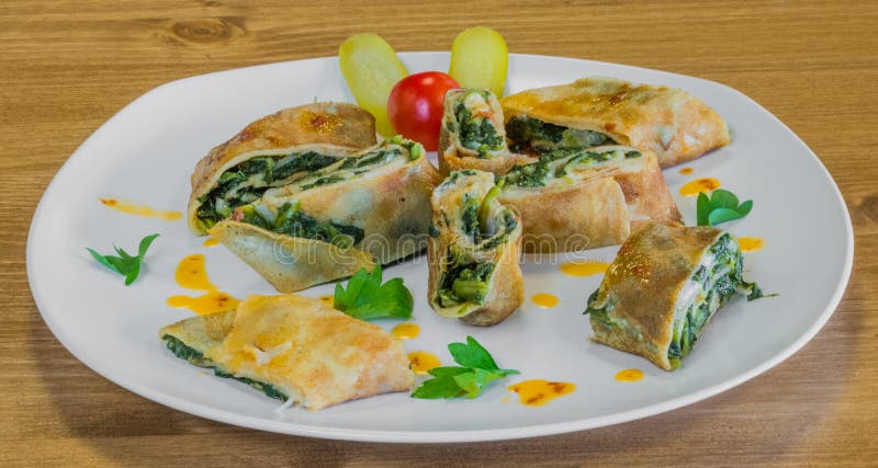 Closeup of delicious wrapped crepe with spinach and pickles beside royalty free stock images Closeup of delicious wrapped crepe with spinach and pickles beside royalty free stock images