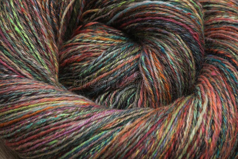 Closeup detail of colourful hand spun sheep wool merino fibres, rolled up in a yarn ball skein. Spun on a traditional spinning wheel. Closeup detail of colourful hand spun sheep wool merino fibres, rolled up in a yarn ball skein. Spun on a traditional spinning wheel