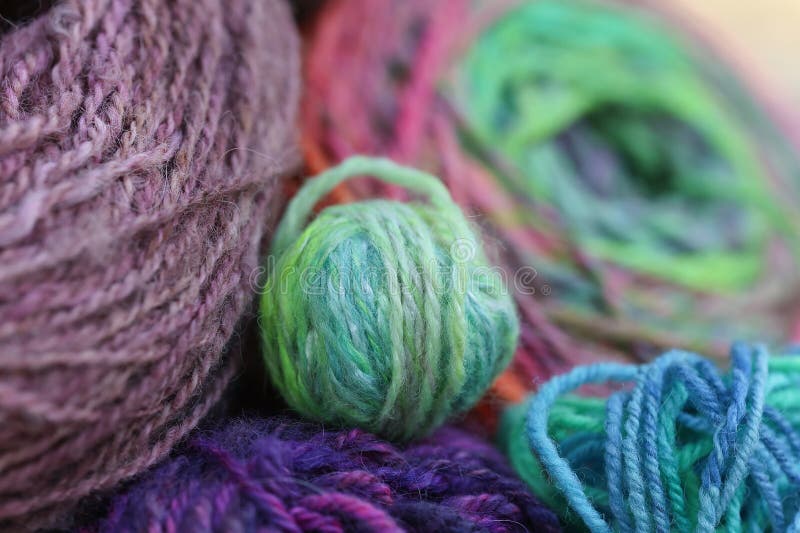 Closeup detail of colourful hand spun sheep wool merino fibres, rolled up in a yarn ball skein. Spun on a traditional spinning wheel