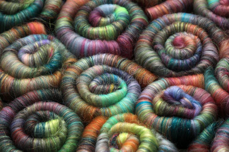 Closeup detail of handmade rolags of sheep wool and other fibres which were blended on a blending board ready for spinning on a handspindle or a traditional spinning wheel. Closeup detail of handmade rolags of sheep wool and other fibres which were blended on a blending board ready for spinning on a handspindle or a traditional spinning wheel.