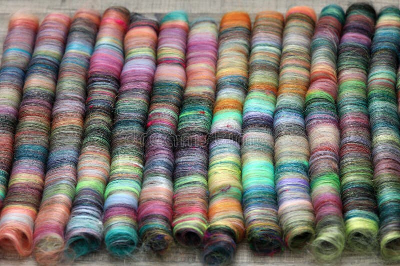 Closeup detail of handmade rolags of sheep wool and other fibres which were blended on a blending board ready for spinning on a handspindle or a traditional spinning wheel. Closeup detail of handmade rolags of sheep wool and other fibres which were blended on a blending board ready for spinning on a handspindle or a traditional spinning wheel.