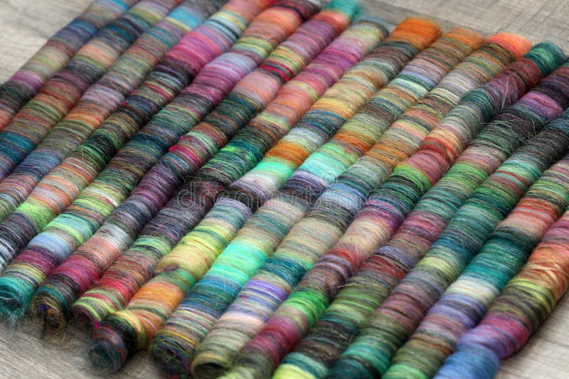 Closeup detail of handmade rolags of sheep wool and other fibres which were blended on a blending board ready for spinning on a handspindle or a traditional spinning wheel. Closeup detail of handmade rolags of sheep wool and other fibres which were blended on a blending board ready for spinning on a handspindle or a traditional spinning wheel.