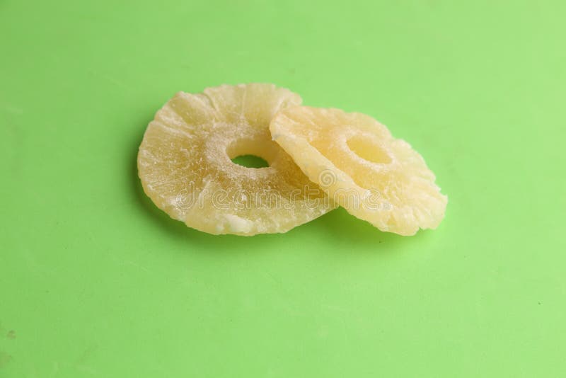 Closeup of Dried Pineapple Slices on a Green Surface Under the Lights
