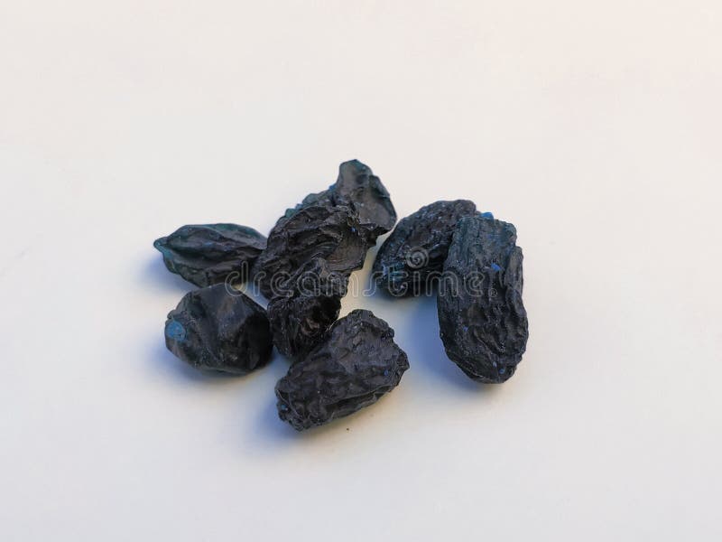 Closeup of Dry Black Raisin Fruit Isolated in a White Background. Heap