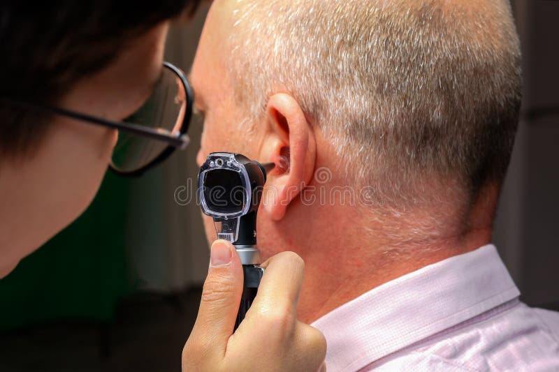 Closeup du médecin examinant caucasien adultes patients homme oreille avec otoscope. photographie stock libre de droits