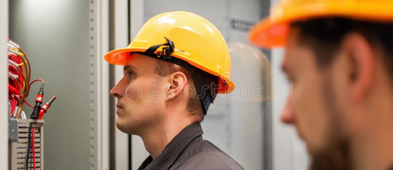 Closeup of electrician engineer works with electric cable wires royalty free stock images