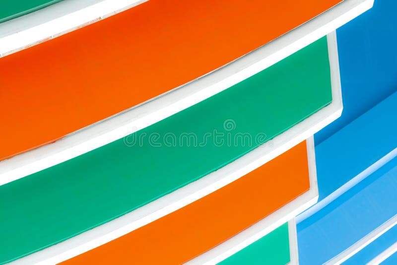 Closeup facade of concrete building. Orange, white, green, and blue building texture background with creative and beautiful stock photography