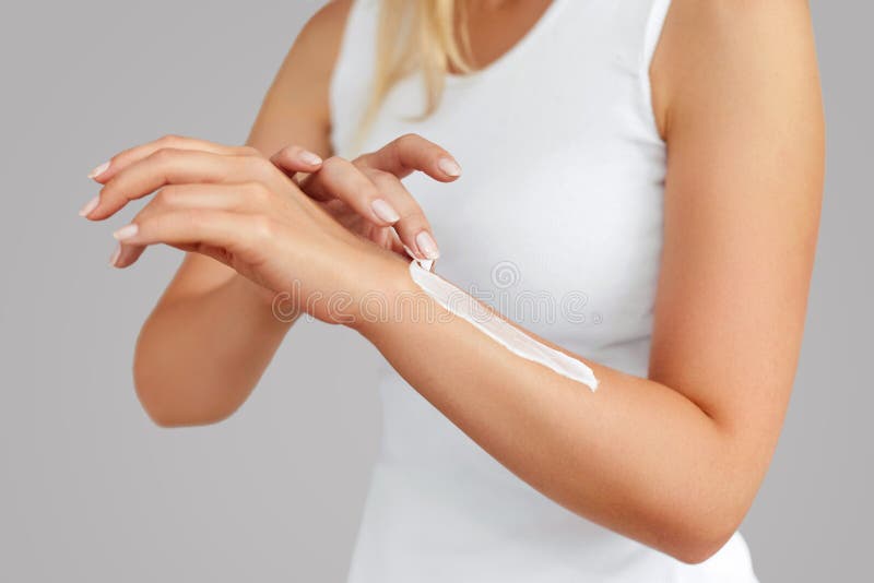 Closeup of female hands applying hand cream.Hand Skin Care. Women use body lotion on your arms. Beauty And Body Care Concept.