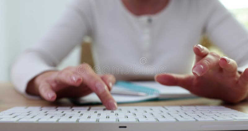 Closeup of female hands typing on white computer keyboard stock footage