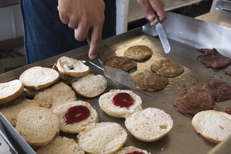 Closeup of Flipping Burger Patties and Warming Buns on an Old Griddle