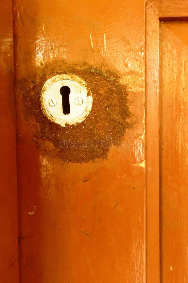 Closeup front view exterior old rusty rough brown wooden door keyhole of iron metal frame with in grungy style and good texture of stock photo Closeup front view exterior old rusty rough brown wooden door keyhole of iron metal frame with in grungy style and good texture of stock photo