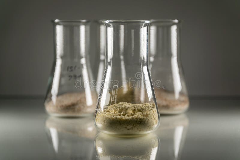 Closeup of glass chemistry flasks with brown chemical powder in them royalty free stock image Closeup of glass chemistry flasks with brown chemical powder in them royalty free stock image