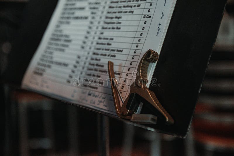 Closeup of a golden guitar capo on a musical note stand