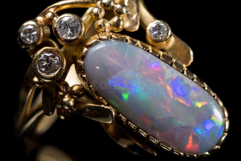 Closeup of a golden ring with a colorful opal gemstone