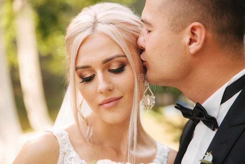 Closeup of groom kissing bride. Beautiful makeup and hairstyle. Portrait of lovely couple royalty free stock image Closeup of groom kissing bride. Beautiful makeup and hairstyle. Portrait of lovely couple royalty free stock image