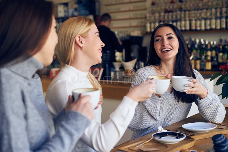 Group of women friends meeting for coffee at cafe royalty free stock photography Group of women friends meeting for coffee at cafe royalty free stock photography