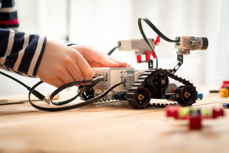 STEM Education, hands of preteen / teenage boy assemble, learn to program and test his robot for school project stock photo