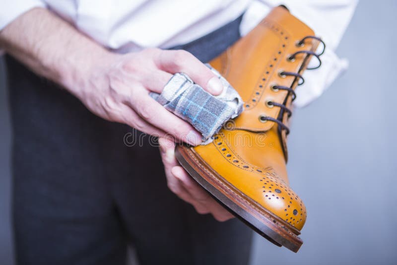 Closeup of hands of Professional Male Shoe Cleaner Using Cloth stock photo