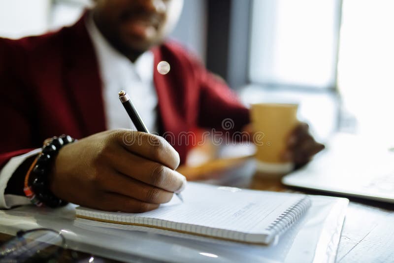 Closeup of hands right handed african manager write on document