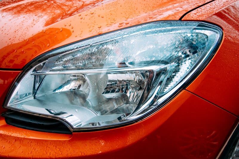 Closeup of Headlamp on Red Car. Front Headlight of Modern Auto Stock