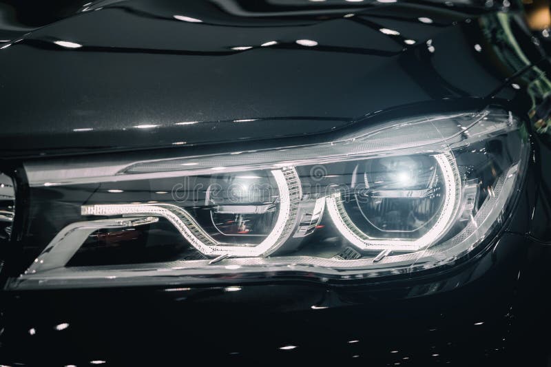 Closeup Headlights of Modern Car during Turn on Light in Night. Stock