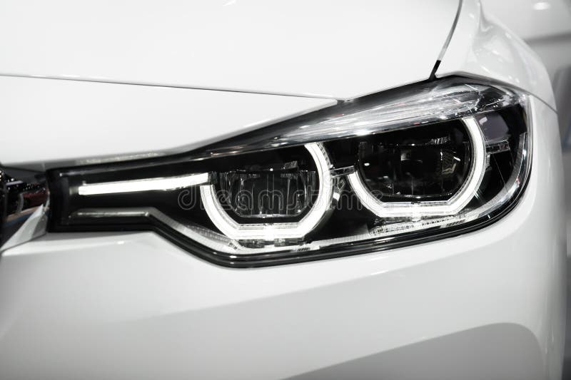 Closeup Headlights of Modern Car during Turn on Light in Night. Stock