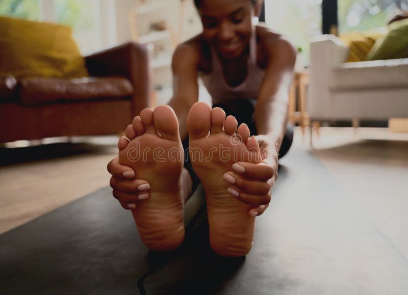 Closeup of Healthy Young Woman Touching Feet while Doing