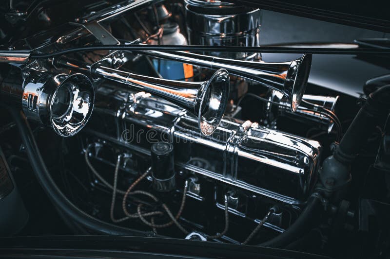 Closeup of a Highshine Chrome Car Engine in a Dark, Industrial Setting