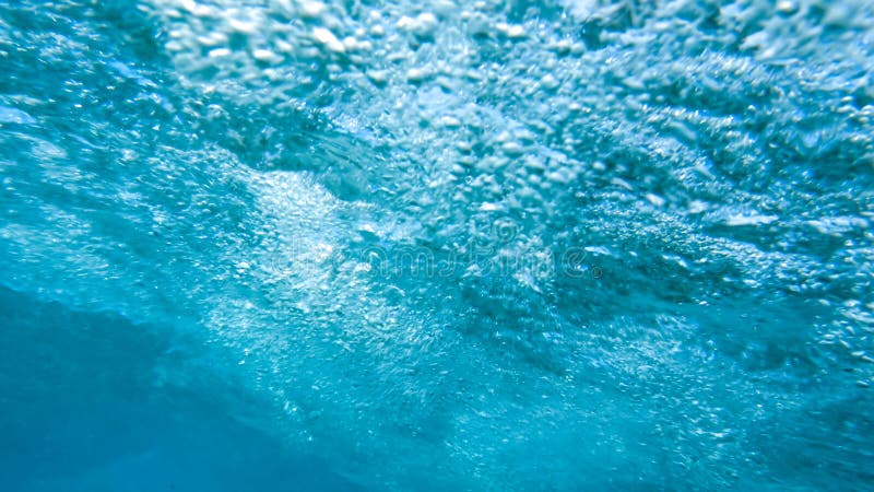 Closeup image of air bubbles in sea water. Shot from the inside of rolling ocean wave tube