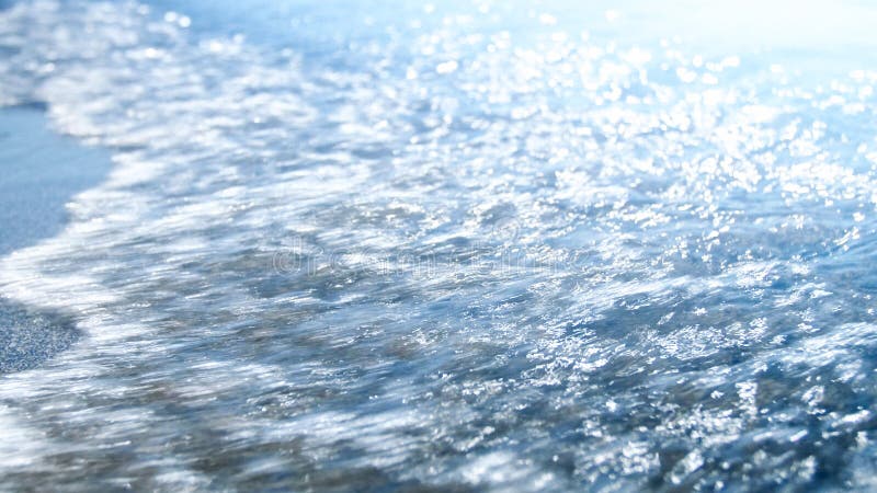 Closeup image of blue sea waves rolling over sandy beach. Abstract out of focus image royalty free stock photo Closeup image of blue sea waves rolling over sandy beach. Abstract out of focus image royalty free stock photo