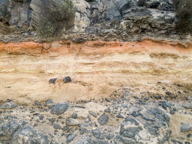 Closeup photo of defferent layers of ground and stone on the mountain slope