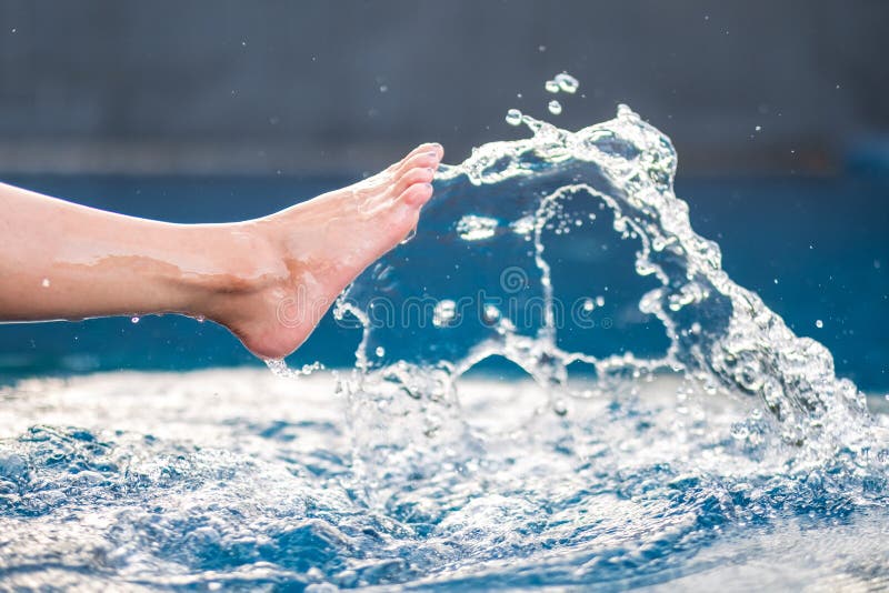 Person's leg kicking a bucket of water - SuperStock