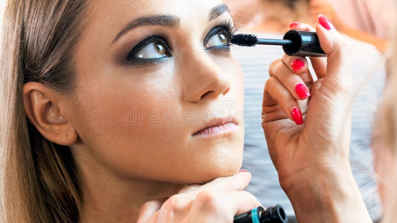 Closeup image of profesinal makeup artist painting model`s eyelashes with mascara stock image Closeup image of profesinal makeup artist painting model`s eyelashes with mascara stock image