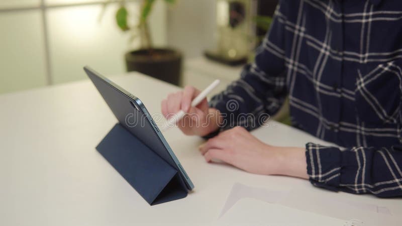 Closeup jeune femme naviguant tablette numérique avec stylet dans un bureau moderne. banque de vidéos