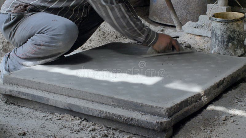 Indian worker making the concrete surface smooth using a float hand tool stock footage