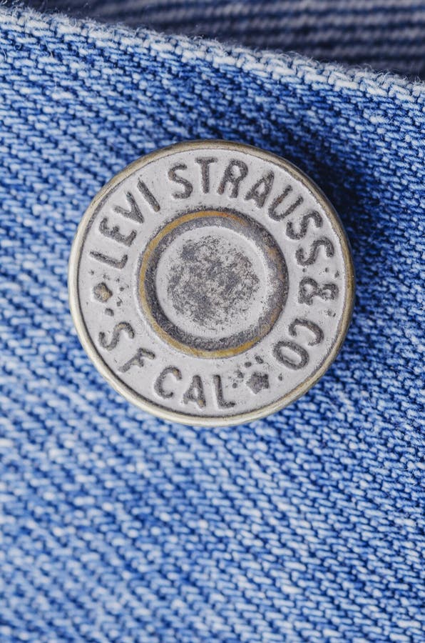 Closeup of Levi Strauss button on blue jeans. royalty free stock photography