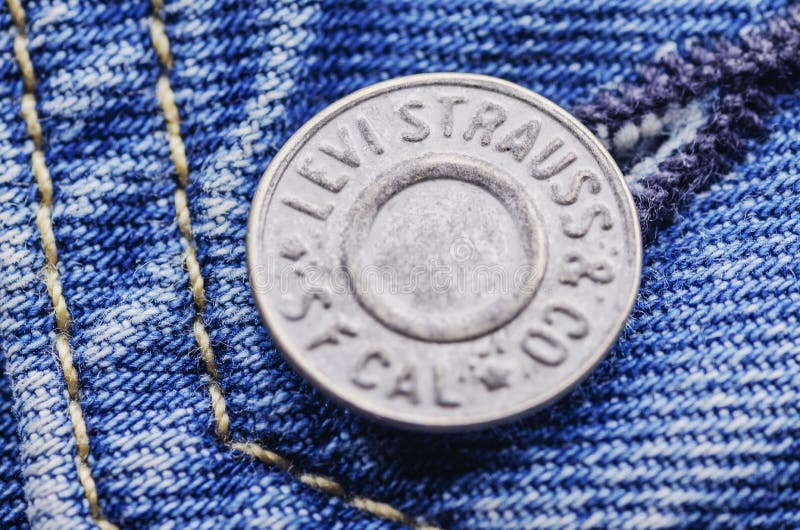 Closeup of Levi Strauss button on blue jeans. stock image