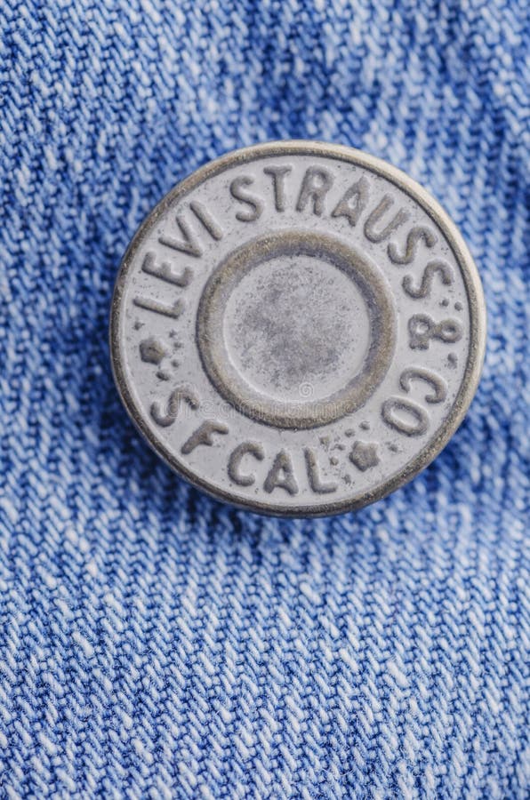Closeup of Levi Strauss button on blue jeans. stock photo