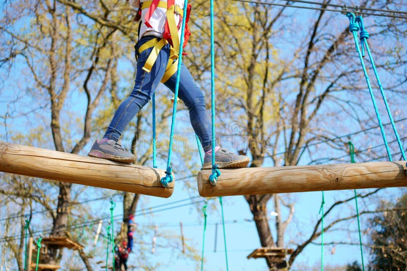 Closeup Little girl playing at adventure park climbing and addressing balance challenges for self esteem. royalty free stock image Closeup Little girl playing at adventure park climbing and addressing balance challenges for self esteem. royalty free stock image
