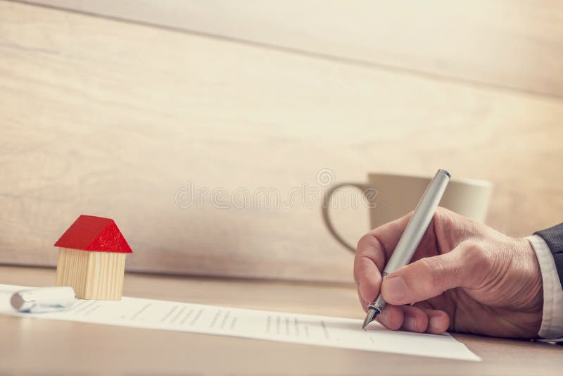 Closeup of male hand signing insurance papers, contract of house