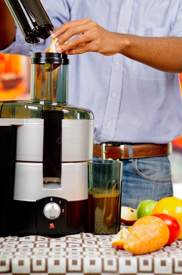 Closeup Man S Hands Using Juice Maker, Inserting Apple Pieces into