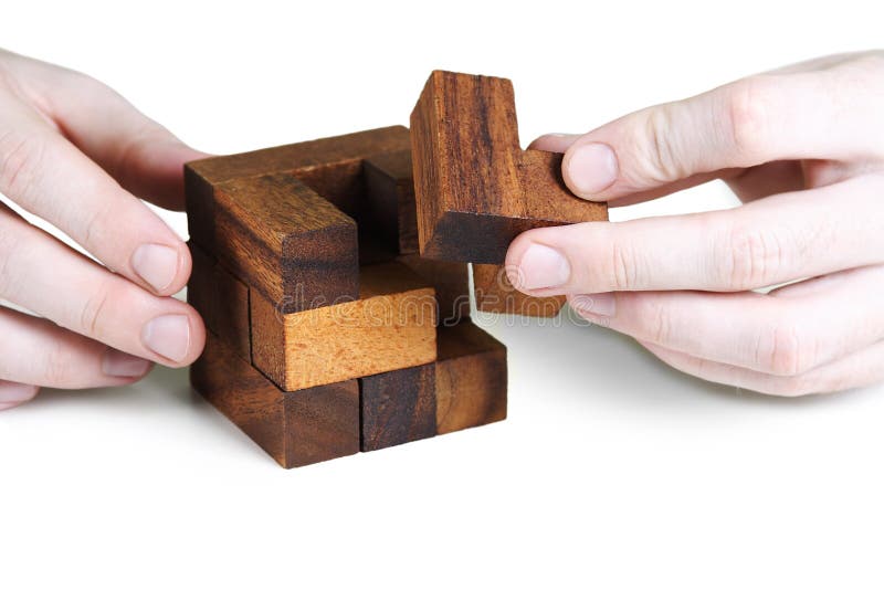 Closeup of mans hands assembling wooden cube