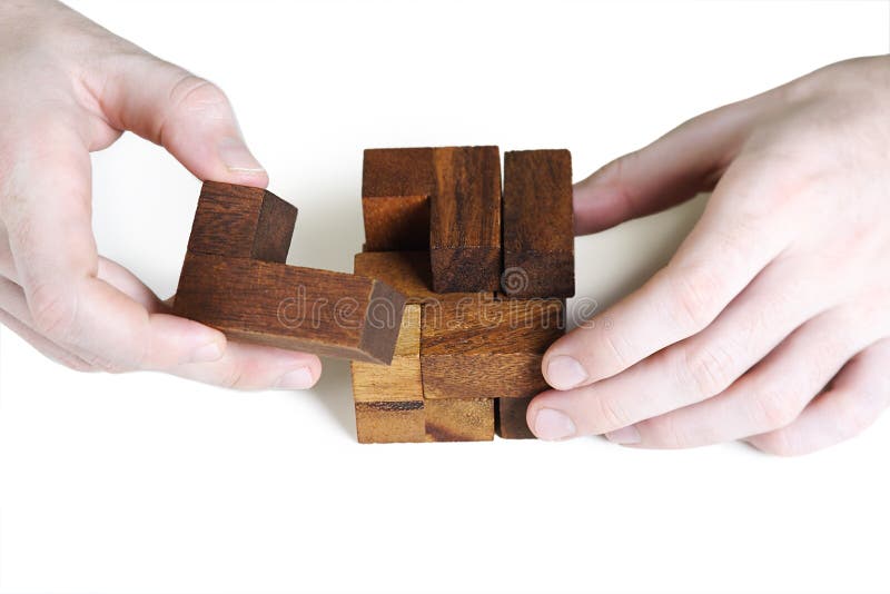 Closeup of mans hands assembling wooden cube